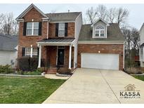 Charming two-story brick home featuring an attached two-car garage and manicured front yard at 1004 Canopy Dr, Indian Trail, NC 28079