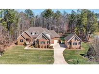 Striking brick home with lush green lawn, long driveway and detached garage at 106 Wolf Hill Dr, Mooresville, NC 28117