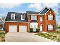 Charming brick two-story home featuring a two-car garage, well-maintained lawn, and classic architectural details at 12332 Ridge Cove Cir, Charlotte, NC 28273