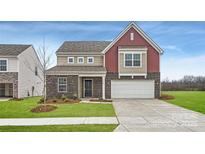 Two-story home featuring a brick facade, two-car garage, and a well-manicured lawn at 1402 Pine Heart Dr, Edgemoor, SC 29712