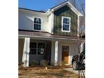 Charming home with a blend of white and green board and batten siding, and covered entryway at 1518 Norris Ave, Charlotte, NC 28206