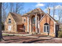 Charming two-story home showcasing a blend of stone and cedar shake siding with a covered front entry at 20338 Christofle Dr, Cornelius, NC 28031