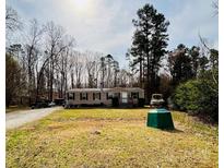 Charming single-story home with neutral siding, black shutters, and a spacious front yard with mature trees at 5128 Green Leaf Ct, Mount Holly, NC 28120