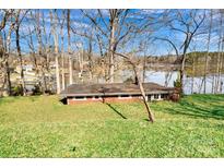 Brick house with lake views, a large grassy yard, and mature trees, offering a serene setting at 7262 Right Angle St, Sherrills Ford, NC 28673