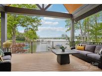 Inviting covered porch boasts serene lake views, comfortable seating, and a tranquil outdoor living space at 121 Kelly Point Ln, Mooresville, NC 28117