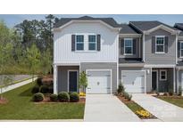 Charming townhome with a one-car garage, manicured lawn, and neutral-colored siding at 2080 Old Rivers Rd, Concord, NC 28027