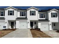 Charming new construction townhome with white siding, black shutters, and an attached one-car garage at 2100 Old Rivers Rd, Concord, NC 28027