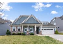 Charming single-Gathering home with a well-manicured lawn, covered porch, stone accents, and an attached two-car garage at 2929 Shumard Dr, Gastonia, NC 28054