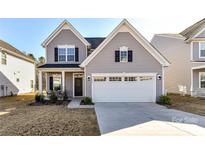 Charming two-story home with gray siding, black shutters, and a two-car garage at 3180 Streamside Dr, Davidson, NC 28036