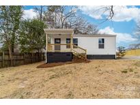 Charming single-story home featuring a covered porch with wood stairs and black painted foundation at 813 Carrid Dr, Gastonia, NC 28052