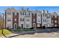 Charming townhome showcasing brick accents, green shutters, and well-maintained landscaping at 10094 Treeside Ln, Matthews, NC 28105