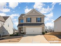 Charming two-story home featuring a two-car garage, landscaped yard, and classic architectural details at 112 Abersham Dr, Mooresville, NC 28115