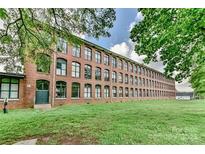 Beautiful brick building with many windows, surrounded by lush green grass and trees at 201 S Hoskins Rd # 131, Charlotte, NC 28208