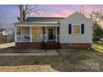 Charming bungalow-style home with a welcoming front porch, brick foundation, and neutral siding at 201 Wiley Ave, York, SC 29745