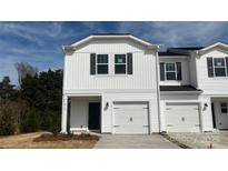 Charming white townhome with a one-car garage and black shutters against a blue sky backdrop at 2130 Old Rivers Rd, Concord, NC 28027