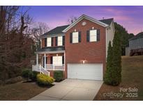 Charming two-story brick home with a well-manicured lawn and attached two-car garage at 302 Flanders Dr, Mooresville, NC 28117