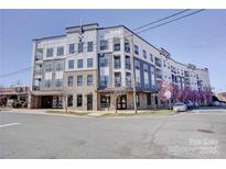 Modern condo building with a combination of brick and siding, as well as beautiful flowering trees at 3630 N Davidson St, Charlotte, NC 28205