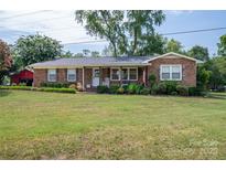 Charming brick ranch home with a well-manicured lawn, mature trees, and an inviting front porch at 7271 Hallman Mill Rd, Vale, NC 28168