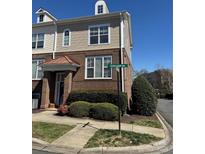 Charming brick-and-siding townhouse with a covered entrance, landscaping, and a street sign at 8410 Scotney Bluff Ave, Charlotte, NC 28273