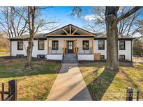 Charming painted brick home featuring a stylish modern porch and walkway at 1206 9Th Nw St, Hickory, NC 28601