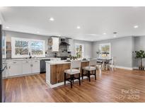 Bright, open kitchen with modern appliances, white cabinets, a wood-accented island, and eat in dining space at 1206 9Th Nw St, Hickory, NC 28601