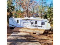 RV with outside deck nestled in trees and ready for outdoor adventuring, relaxation and enjoying nature at 131 Twin Bluff Trl # 40, Mount Gilead, NC 27306