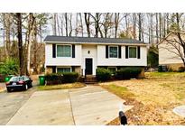 Charming split-level home featuring a well-maintained front yard with a long driveway and mature trees at 1707 Van Dyke Dr, Charlotte, NC 28213