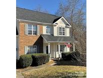 Charming two-story townhome with brick accents, manicured bushes, and a welcoming front porch at 1941 Olsen Ln, Charlotte, NC 28213