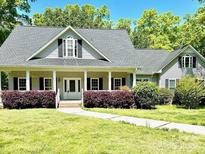 Charming home with a covered front porch and well-manicured landscaping creating inviting curb appeal at 2025 Sojourn Rd, Marshville, NC 28103
