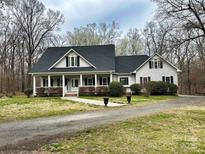 Charming home with a large, inviting front porch, a well-manicured lawn and established landscaping at 2025 Sojourn Rd, Marshville, NC 28103