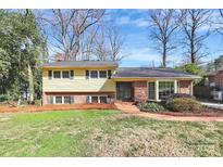 Charming two-story home with a combination of yellow siding, brick accents, and a well-maintained lawn at 3615 Henshaw Rd, Charlotte, NC 28209