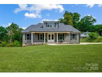 Charming home featuring a covered porch, dormer window, and manicured lawn at 388 Speedway Nw Pl # 1, Concord, NC 28027