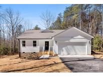 Charming single-story home featuring a two-car garage, a welcoming porch, and a well-manicured front yard at 433 Cornerstone Dr, Taylorsville, NC 28681