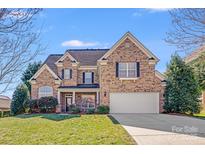 Charming two-story brick home boasts manicured lawn and attached two-car garage at 485 Sutro Forest Nw Dr, Concord, NC 28027