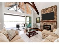 Cozy living room with stone fireplace and floor-to-ceiling windows showcasing lake views at 5086 Windward Point Ln, Denver, NC 28037