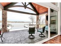 Covered patio showcasing an outdoor pool and beautiful lake views at 5086 Windward Point Ln, Denver, NC 28037