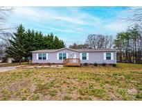 Charming single-story home features a wooden porch, well-maintained lawn, and picturesque landscaping at 80 Sunset Dr, Taylorsville, NC 28681