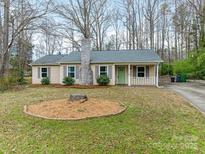 Charming single-story home features a well-maintained yard and classic brick chimney at 8101 Coxwood Ct, Charlotte, NC 28227