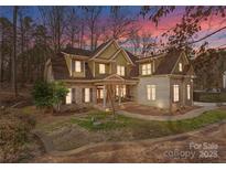 Charming two-story home with stone and siding, complemented by a meticulously landscaped front yard at 109 Hawksnest Ln, Mooresville, NC 28117