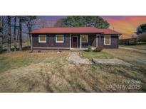 Charming home featuring a red roof, brown siding, and a stone pathway leading to the front door at 127 Barry Oak Rd, Statesville, NC 28625