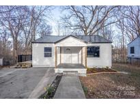 Charming single-story home with a gray metal roof, inviting front porch, and manicured landscaping at 1605 5Th St, Statesville, NC 28625