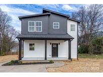 Charming two-story home featuring a covered porch and modern black and white exterior at 320 Cabarrus W Ave, Concord, NC 28025