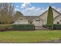 Charming stone home featuring manicured lawn and landscaping beneath a beautiful sky at 4709 Polo Gate Blvd, Charlotte, NC 28216