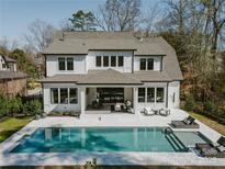 Stunning backyard featuring a sparkling pool, cozy patio, and lush landscaping of this two-story home at 5608 Closeburn Rd, Charlotte, NC 28210