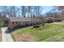 Charming brick ranch home featuring a well-maintained lawn and mature landscaping at 710 Peranna Pl, Charlotte, NC 28211