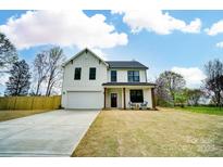 Charming two-story white farmhouse with a well-manicured lawn and a cozy front porch at 9615 Riviera Dr, Sherrills Ford, NC 28673