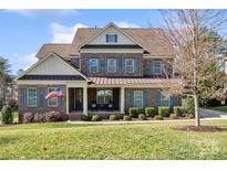 Charming two-story brick home with an American flag and inviting front porch at 130 Monteray Oaks Cir, Fort Mill, SC 29715