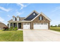 Charming brick home with a three-car garage, black shutters and a beautifully maintained lawn at 1300 Dali Blvd, Mount Holly, NC 28120