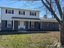 Charming two-story home with a covered front porch and a well-manicured front lawn and classic black shutters at 303 Bost St, Kannapolis, NC 28081