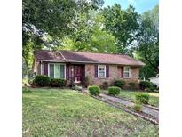 Charming brick home featuring a well-manicured lawn and beautiful, purple accents on the door and shutters at 3701 Seaman Dr, Charlotte, NC 28217